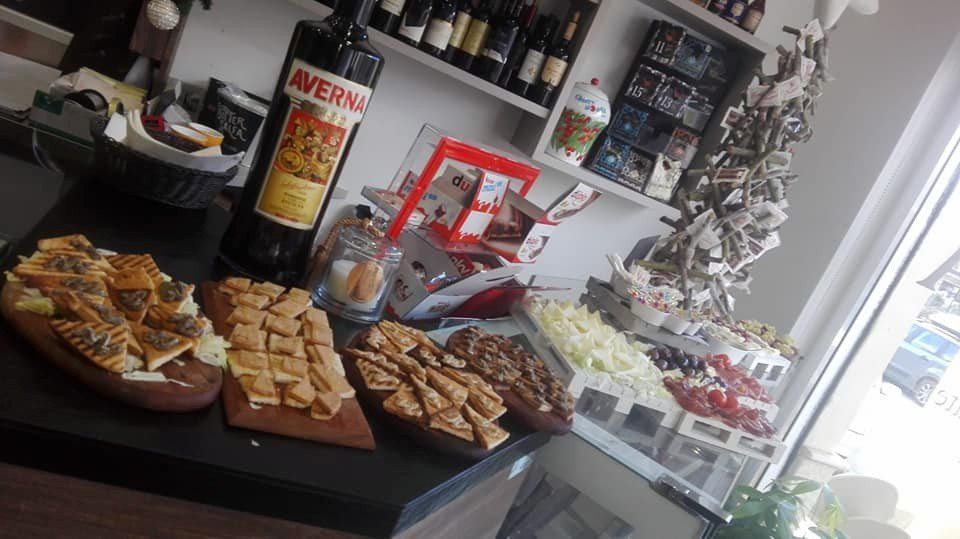 Un tavolo apparecchiato con una varietà di cibo per aperitivo e una bottiglia di vino.