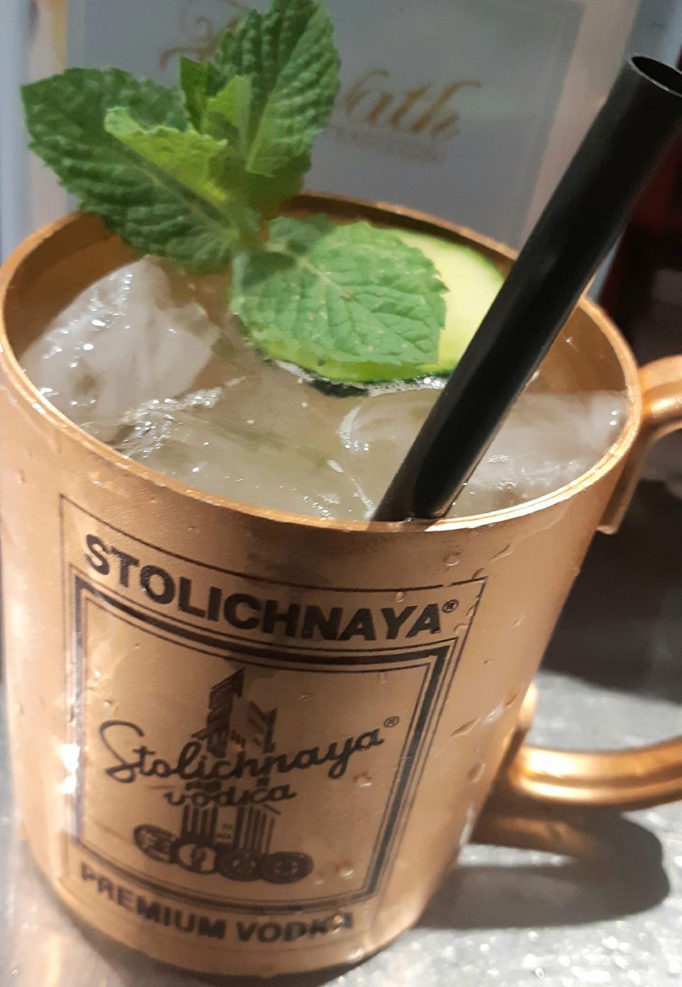Una tazza di vodka stolichnaya con una cannuccia dentro