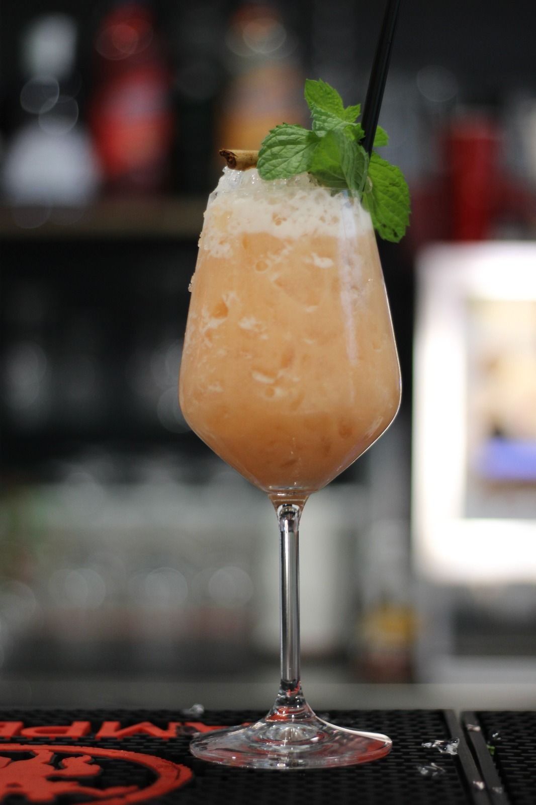 Un primo piano di un drink in un bicchiere da vino su un bar