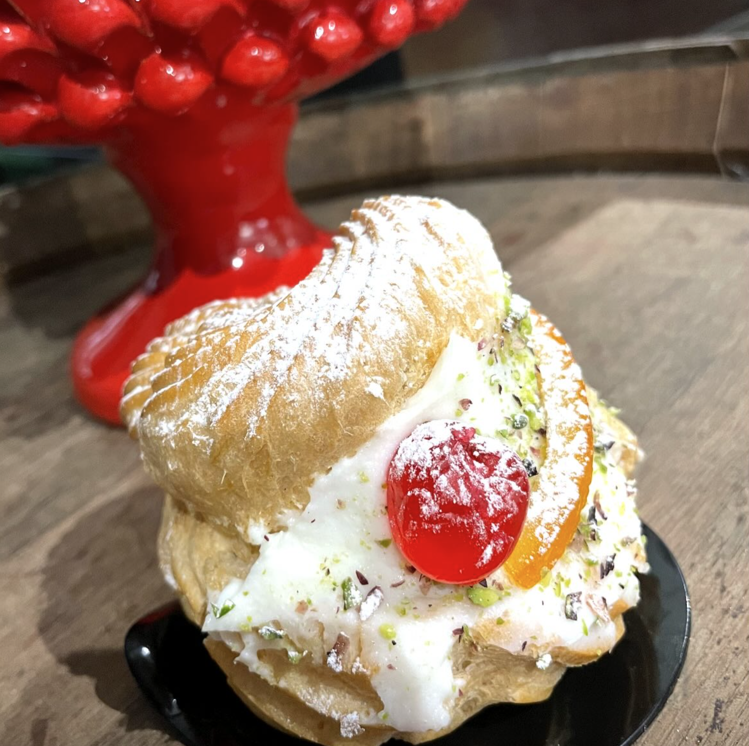 Una pasta sfoglia con zucchero a velo e una ciliegia in cima