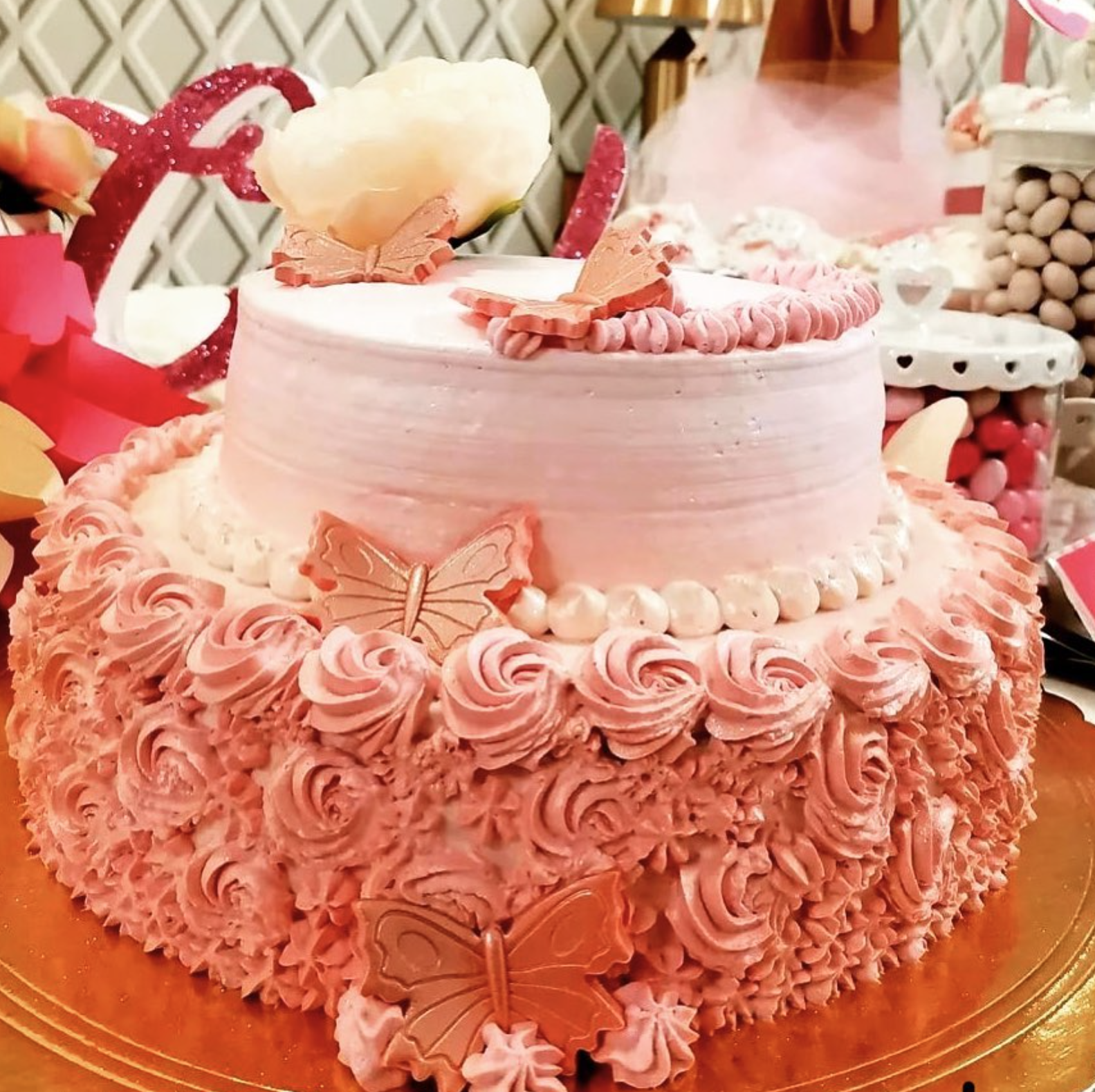 Una torta con glassa rosa e farfalle sopra