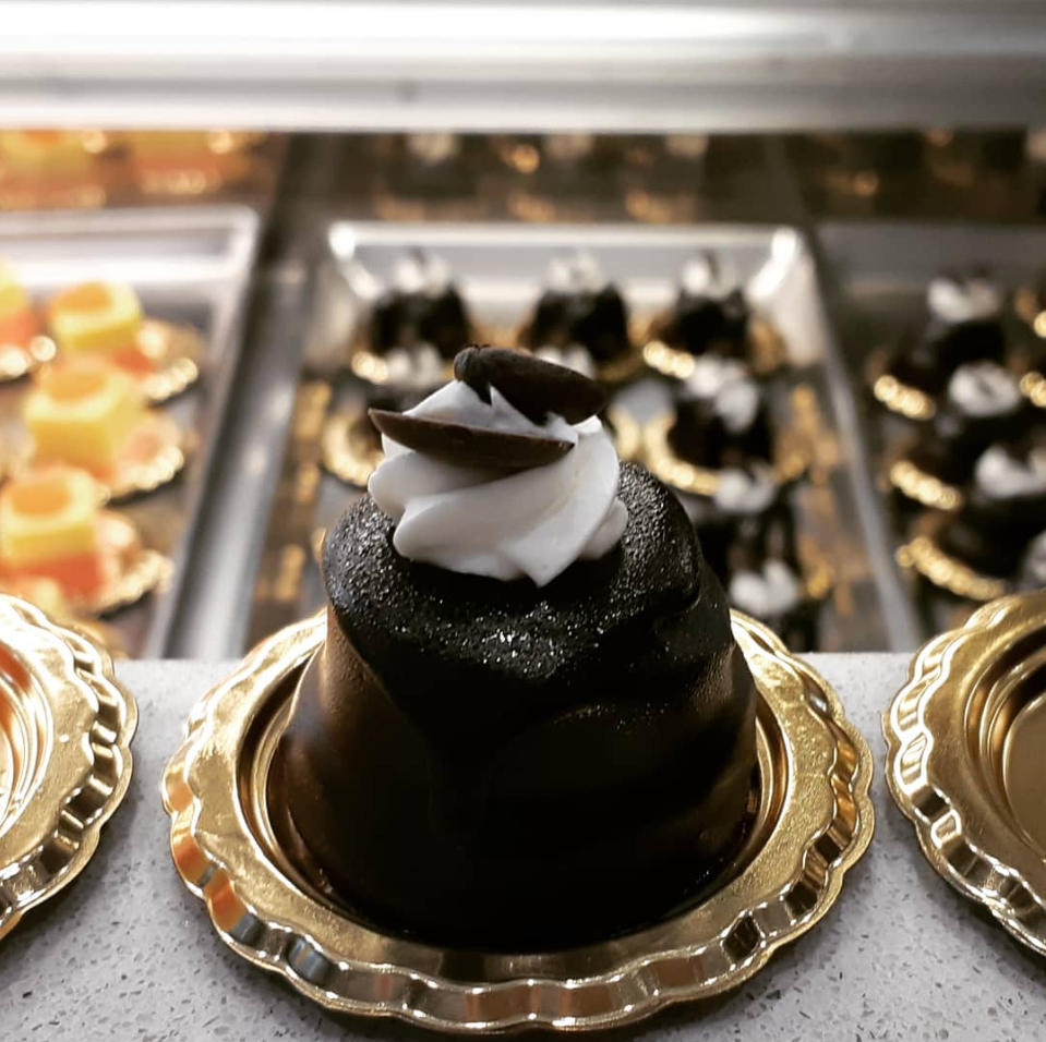 Una torta al cioccolato con panna montata sopra è su un piatto d'oro