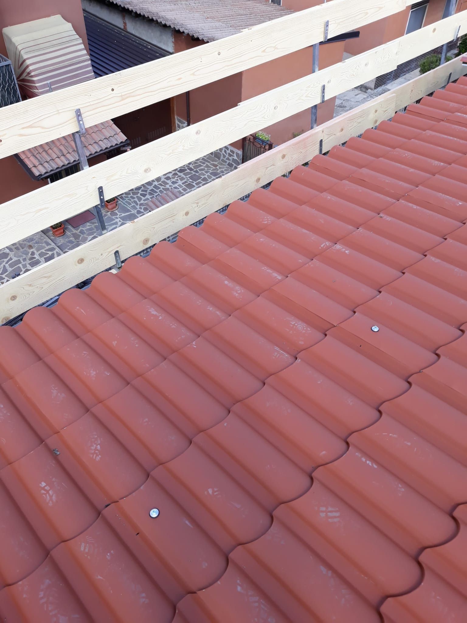Un tetto di tegole rosse con una ringhiera bianca in cima