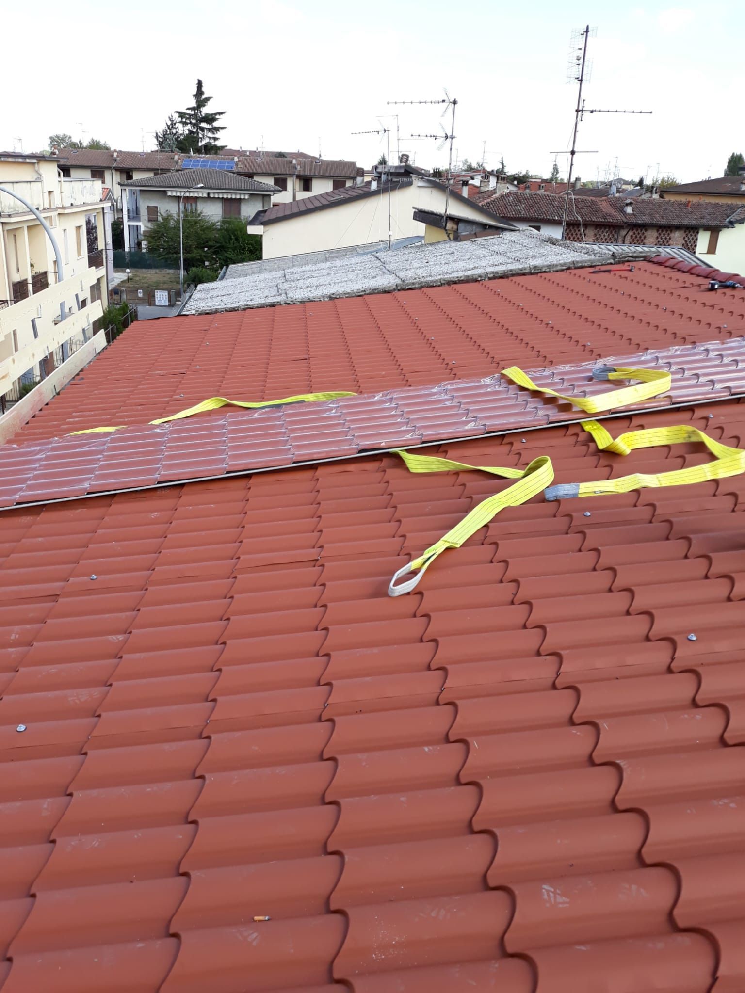 Un tetto di tegole rosse con una cinghia gialla sopra