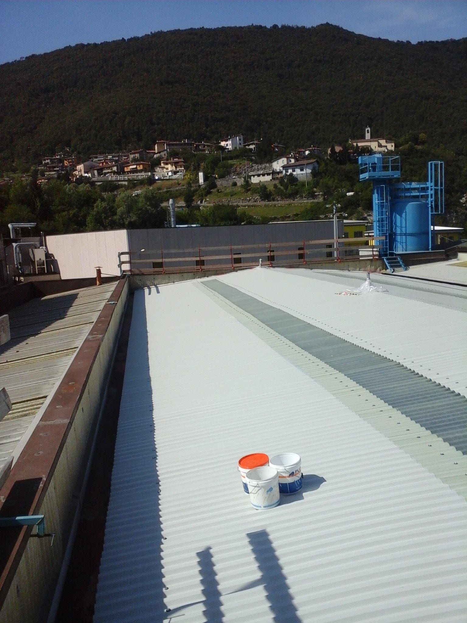 Due secchi di vernice sono appoggiati sul tetto di un edificio