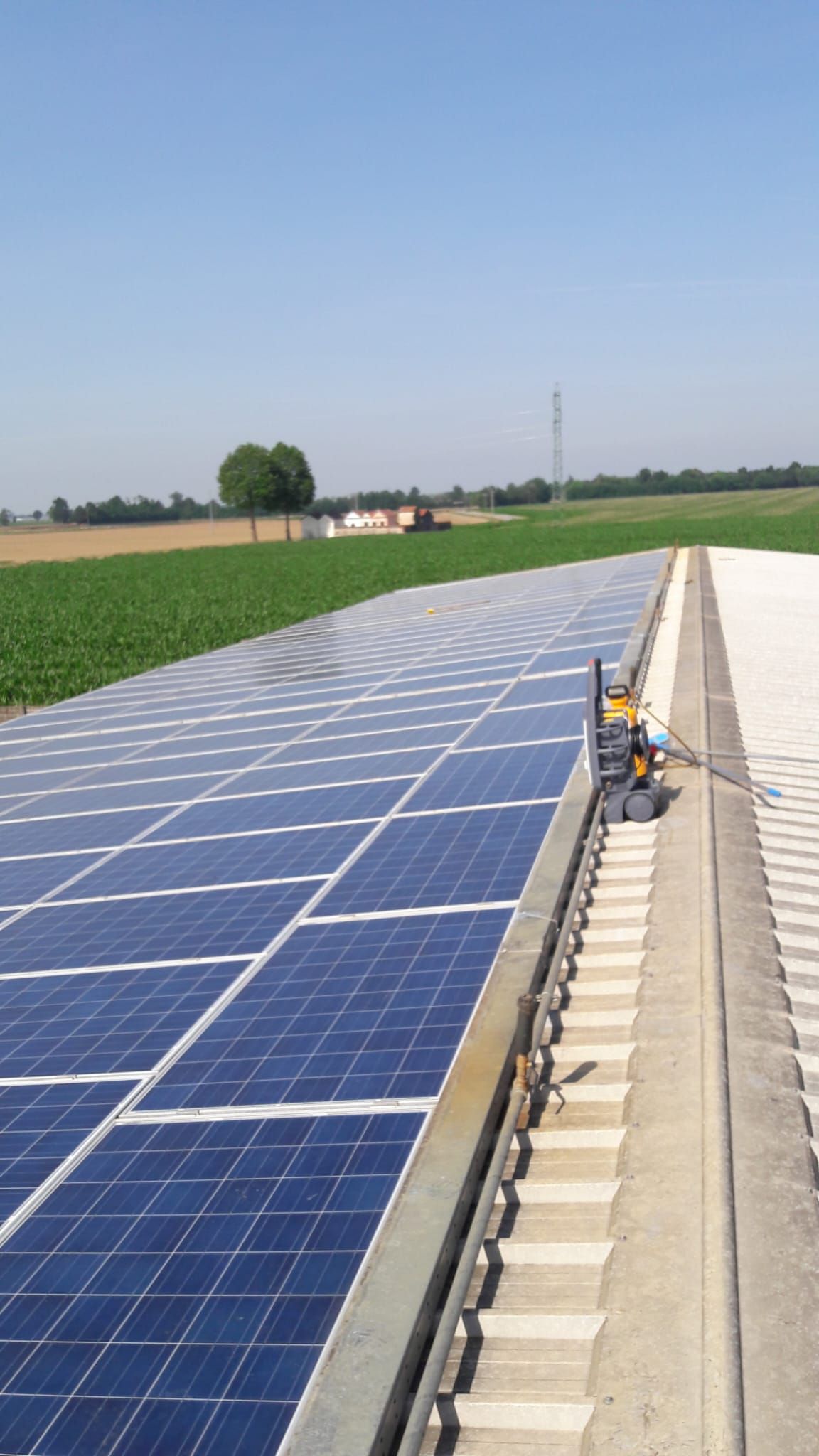 Una fila di pannelli solari è posizionata sopra una superficie di cemento.