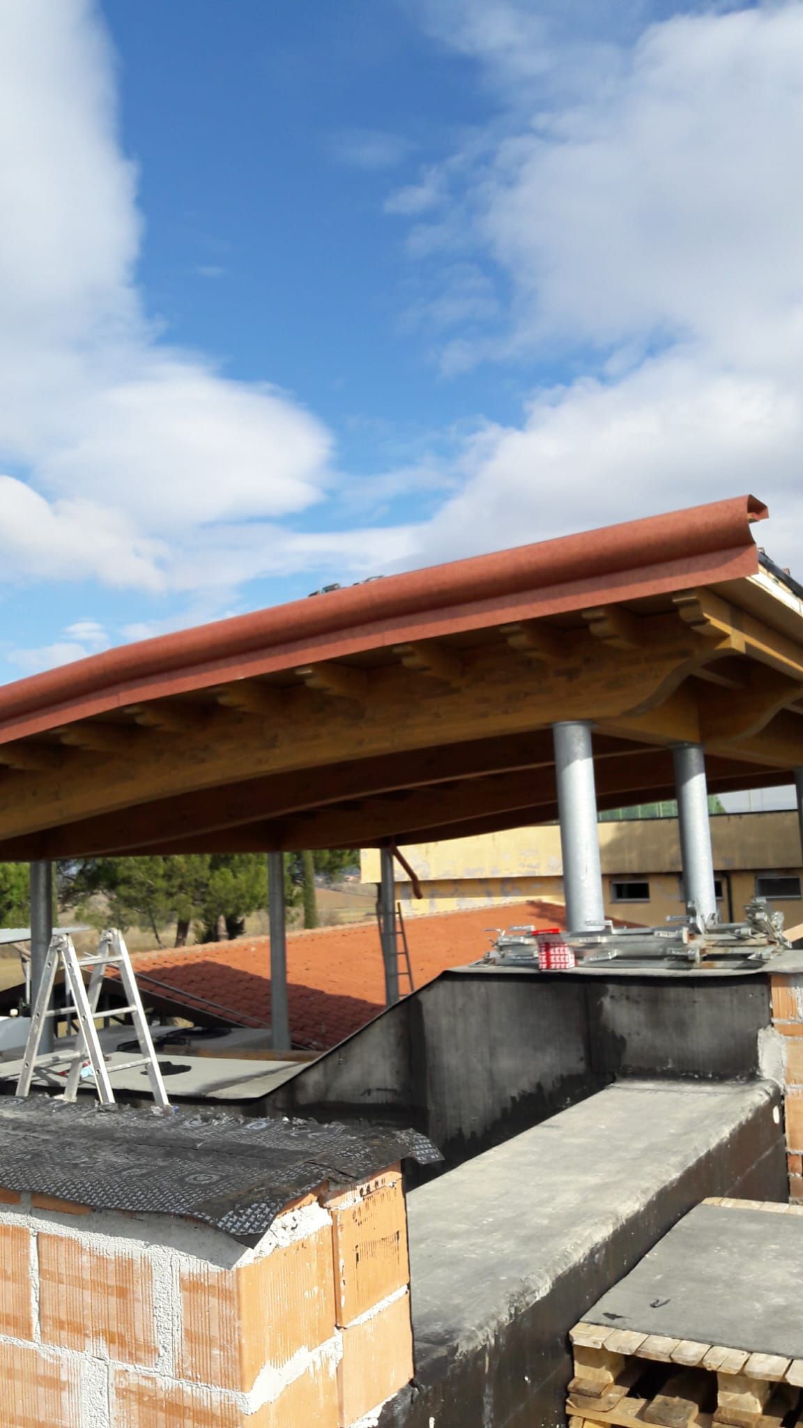 Si sta costruendo un tetto sopra un edificio in mattoni.