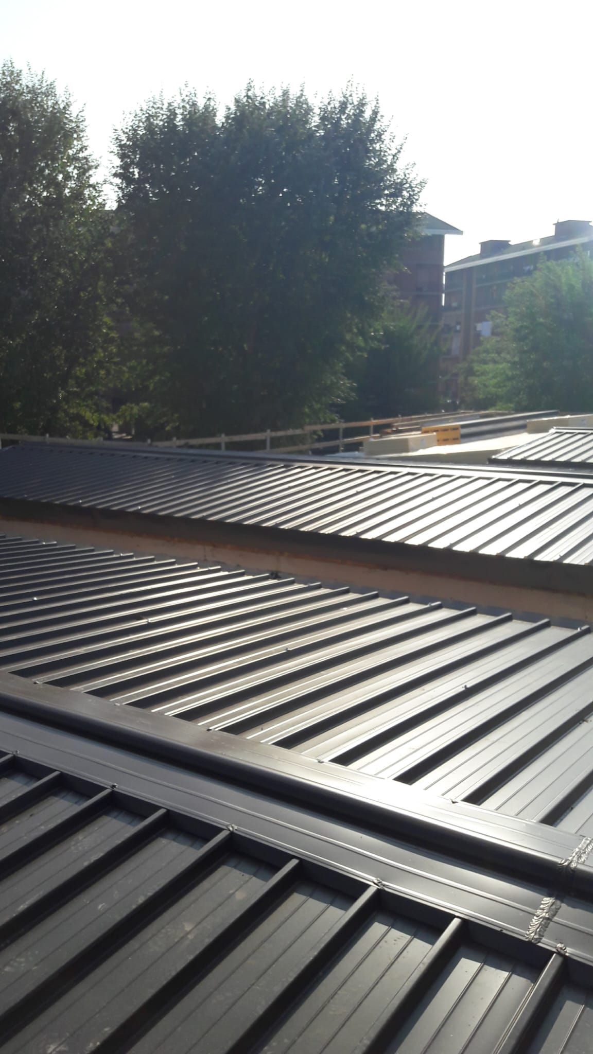 Un primo piano di un tetto con alberi sullo sfondo