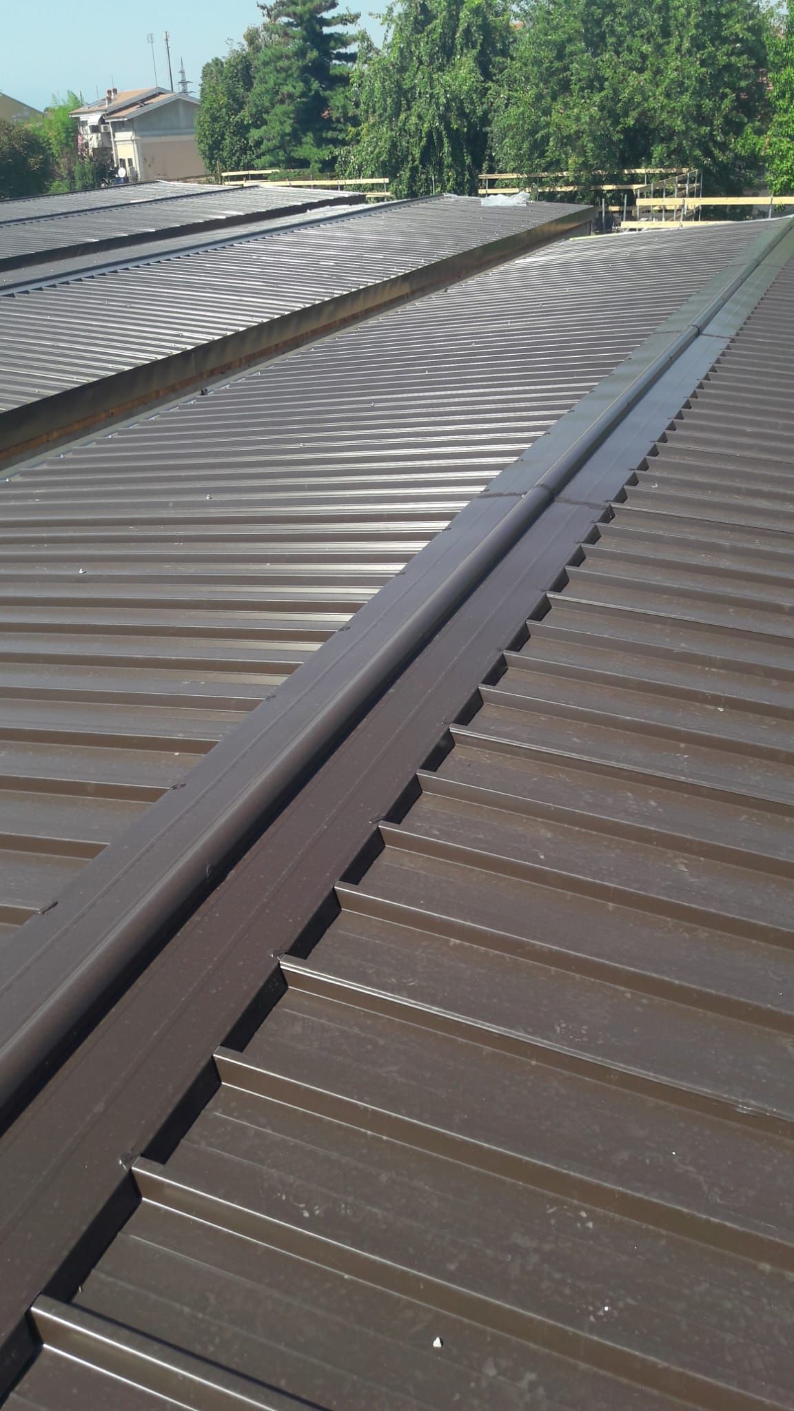 Un primo piano di un tetto marrone con alberi sullo sfondo