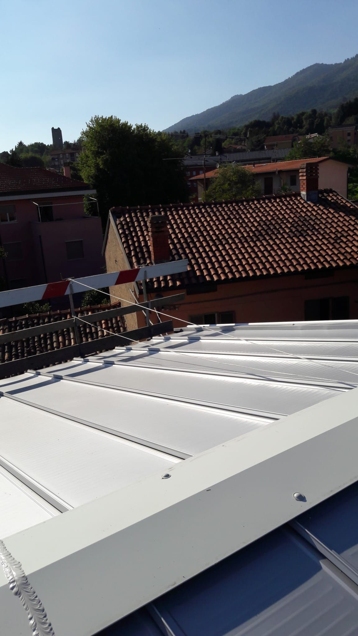 Un tetto bianco con vista su una città e sulle montagne sullo sfondo