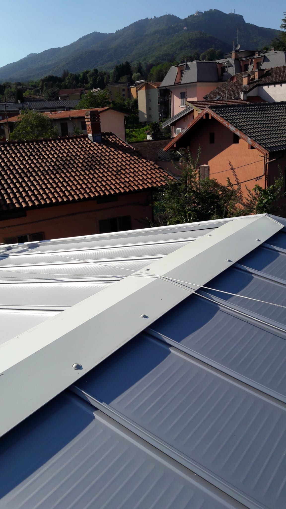 Un tetto con vista su una città e montagne sullo sfondo