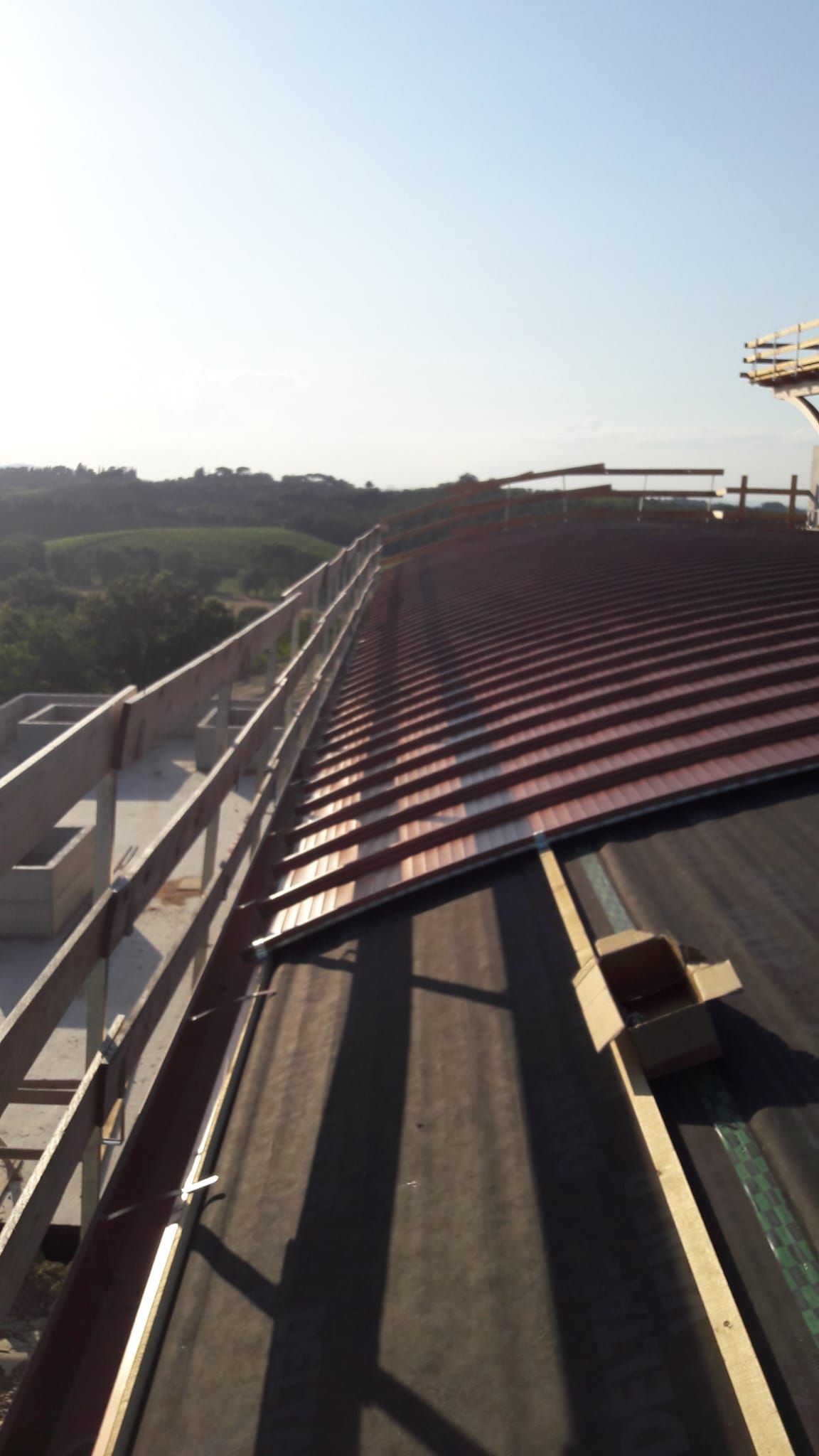 Un tetto con una ringhiera e un cielo azzurro sullo sfondo