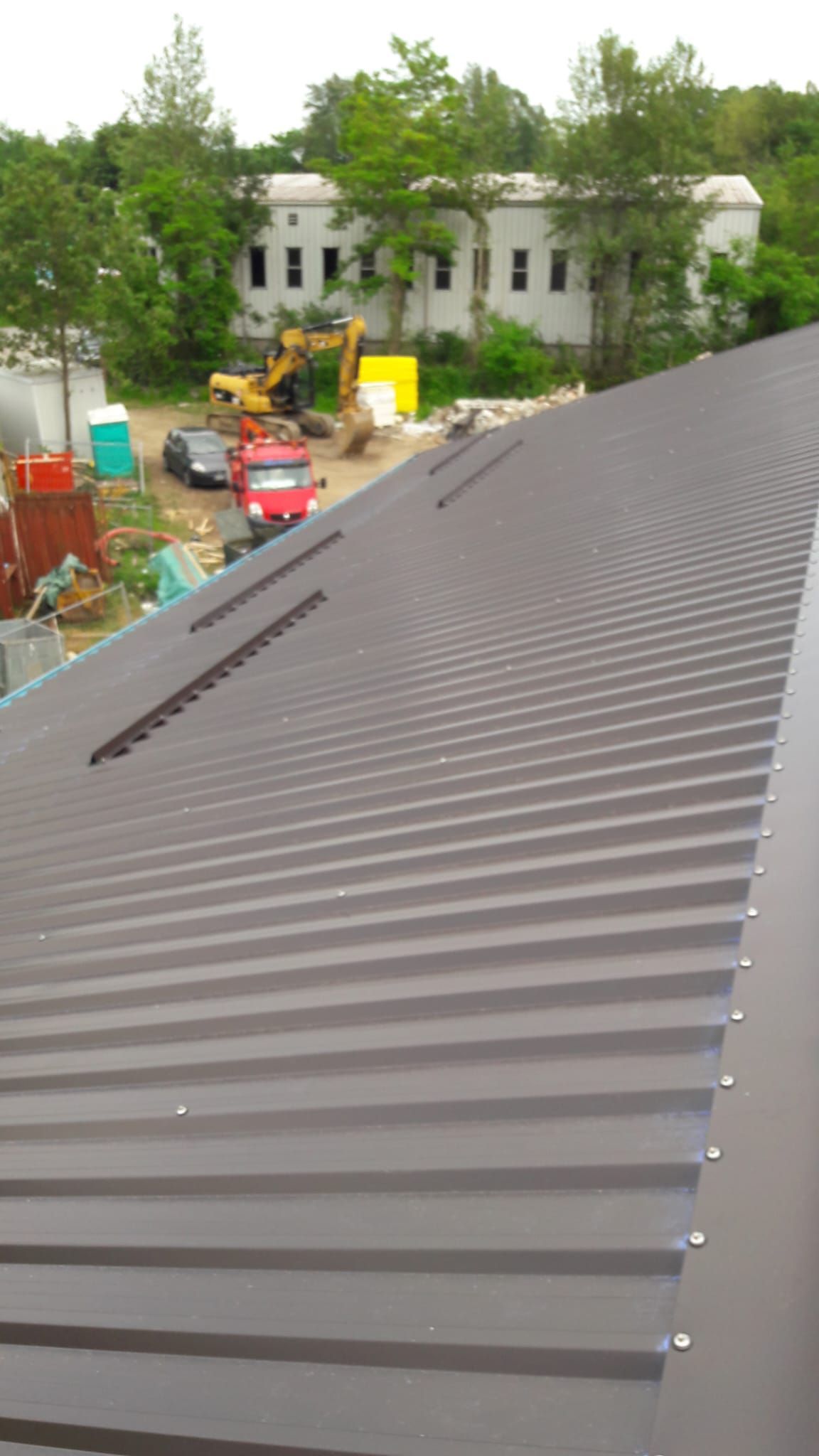 Un camion rosso è parcheggiato sul lato di un edificio in costruzione.