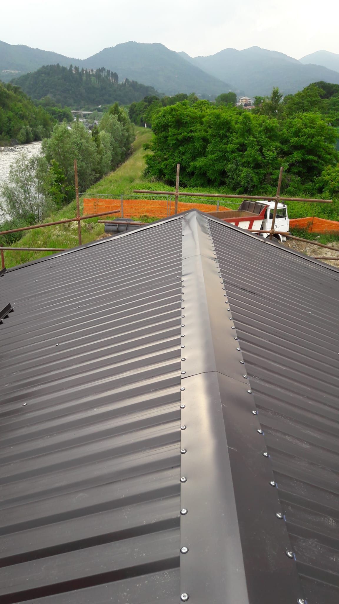 Un tetto con una valle al centro e montagne sullo sfondo.
