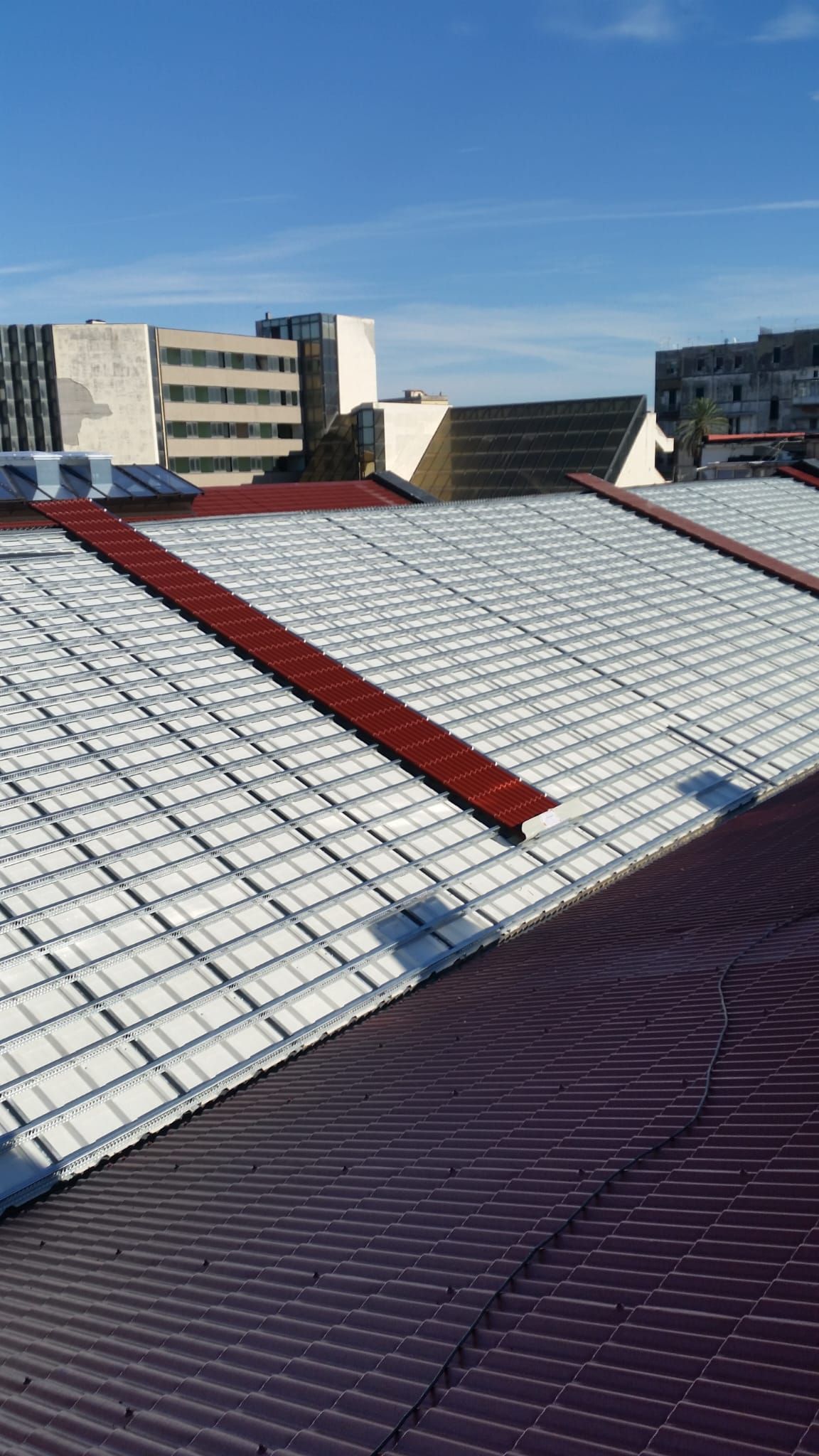 Un tetto con tante tegole e un cielo azzurro sullo sfondo.