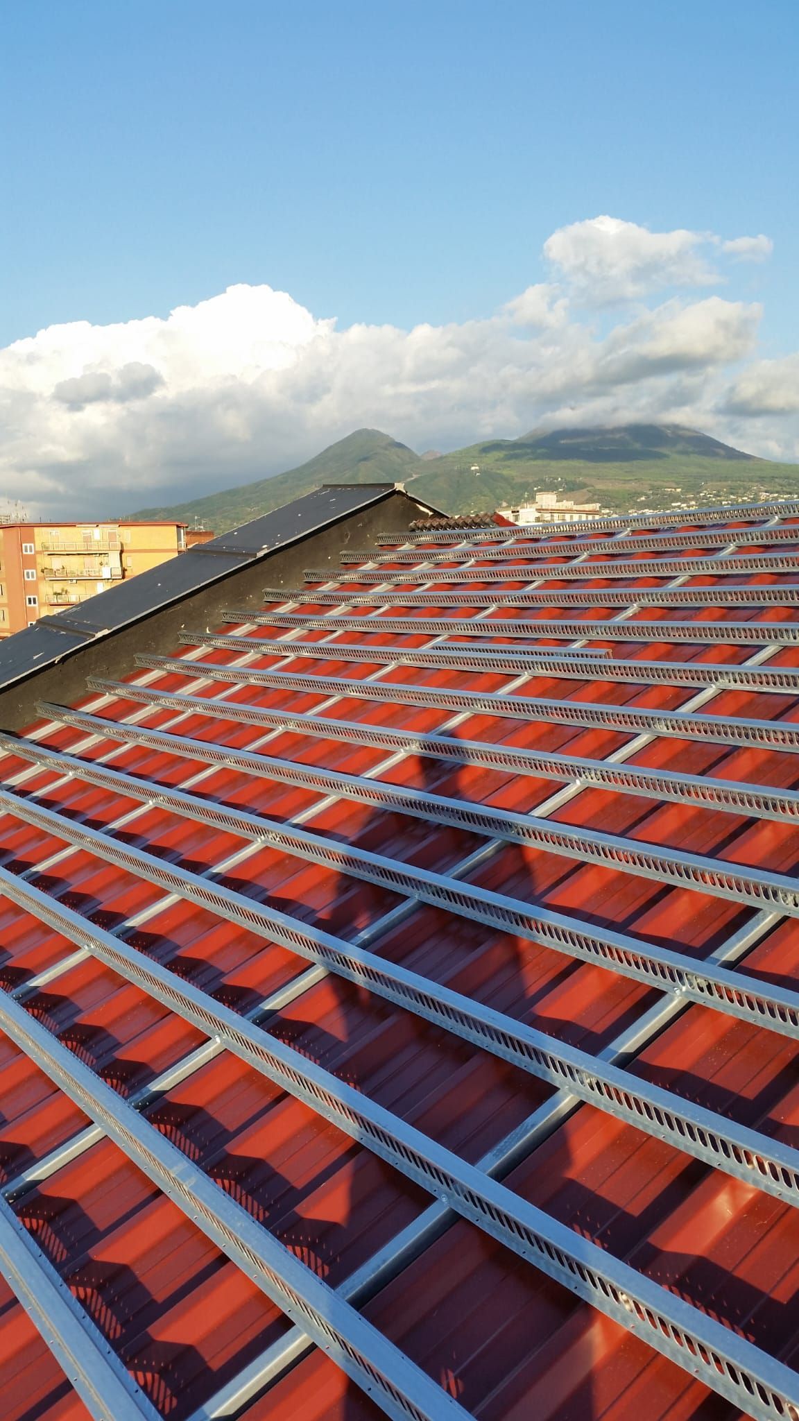 Un tetto di tegole rosse con molti pannelli solari.