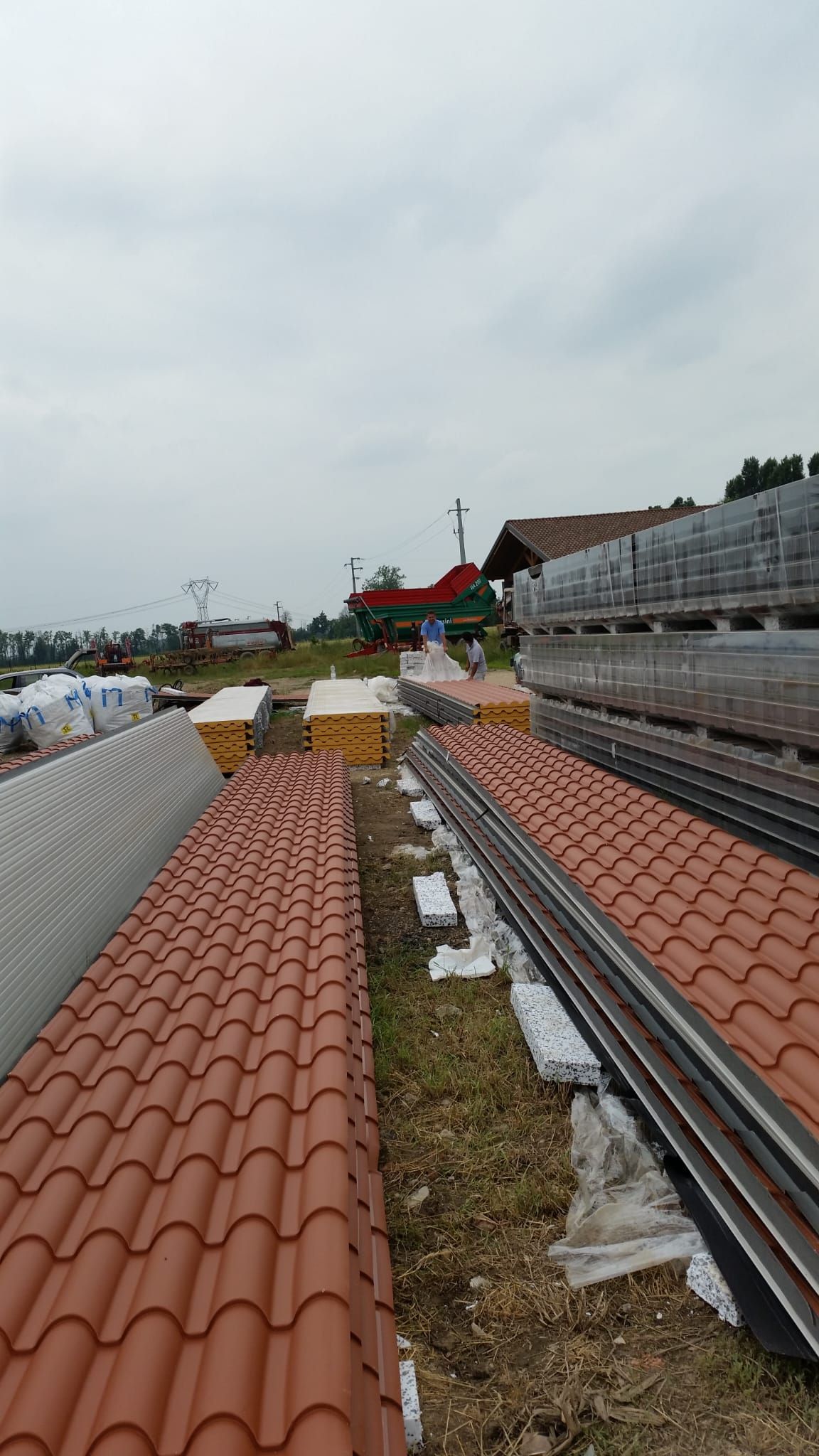 Una fila di tegole rosse sono impilate l'una sull'altra su un tetto.