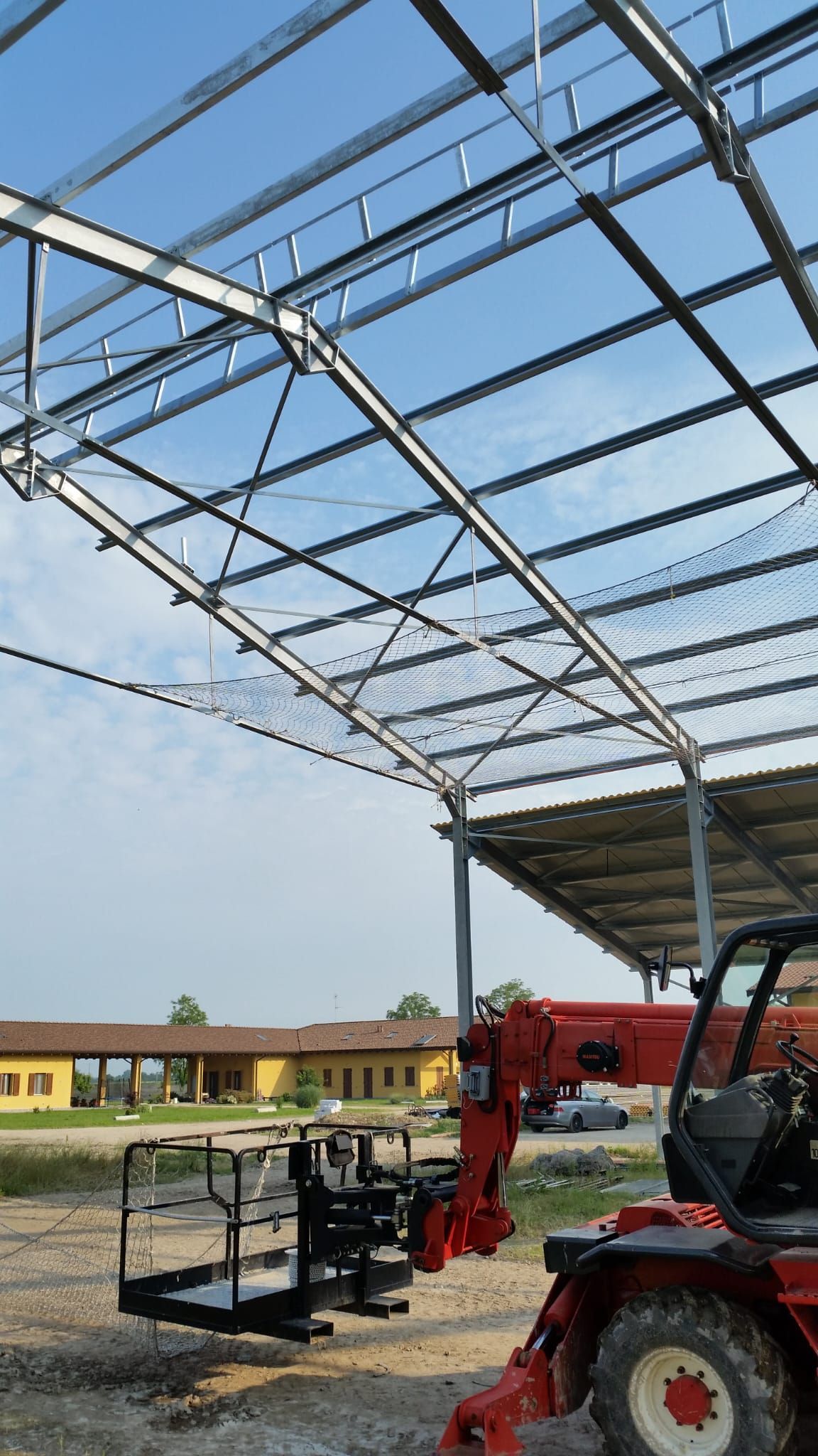 Un trattore rosso è parcheggiato davanti a un edificio in costruzione.