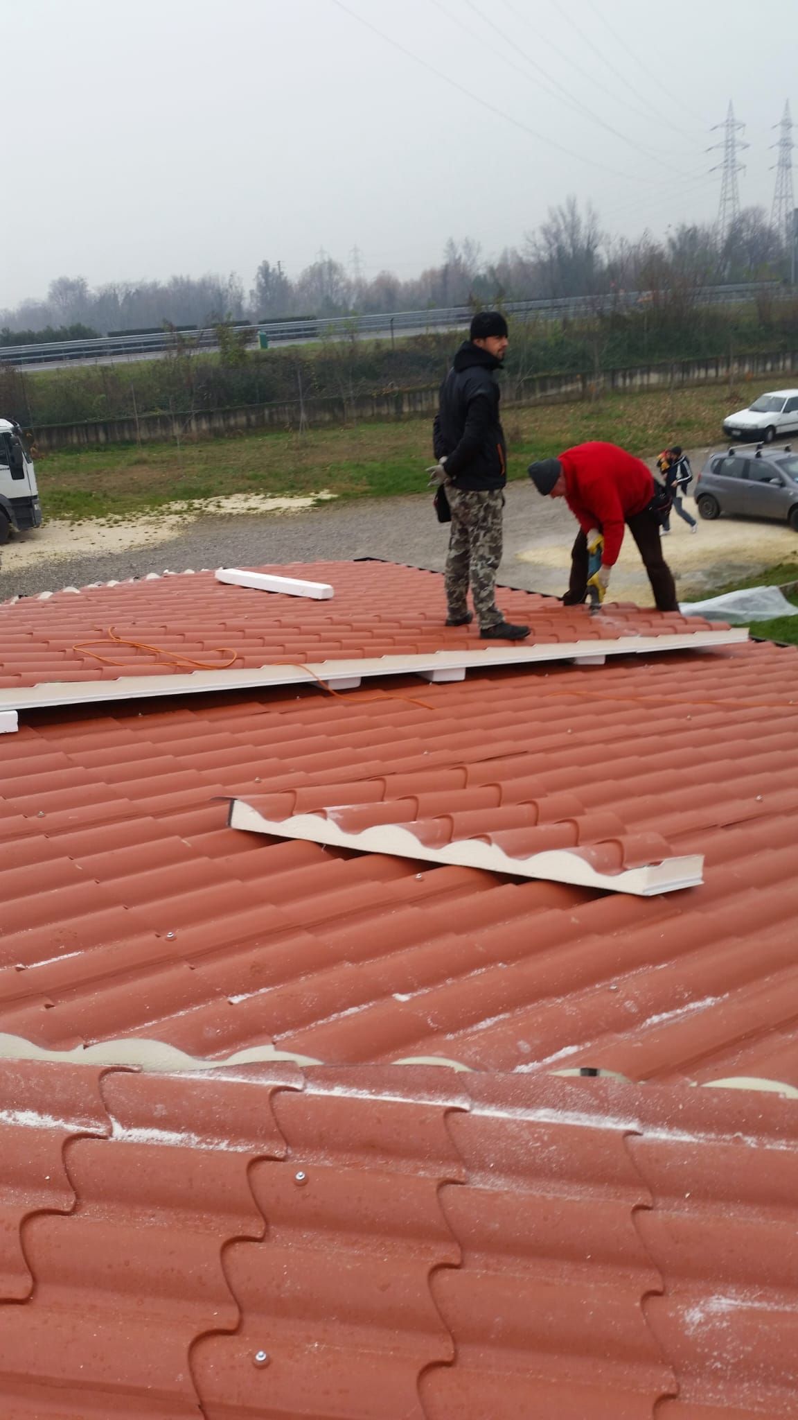 Due uomini stanno lavorando sul tetto di un edificio.