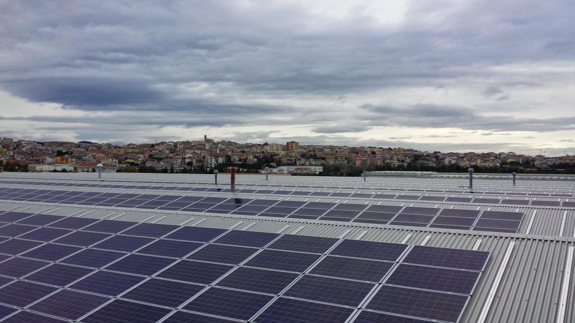 Ci sono molti pannelli solari sul tetto di un edificio.