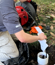 A man is cleaning a pipe with a milwaukee drain cleaner