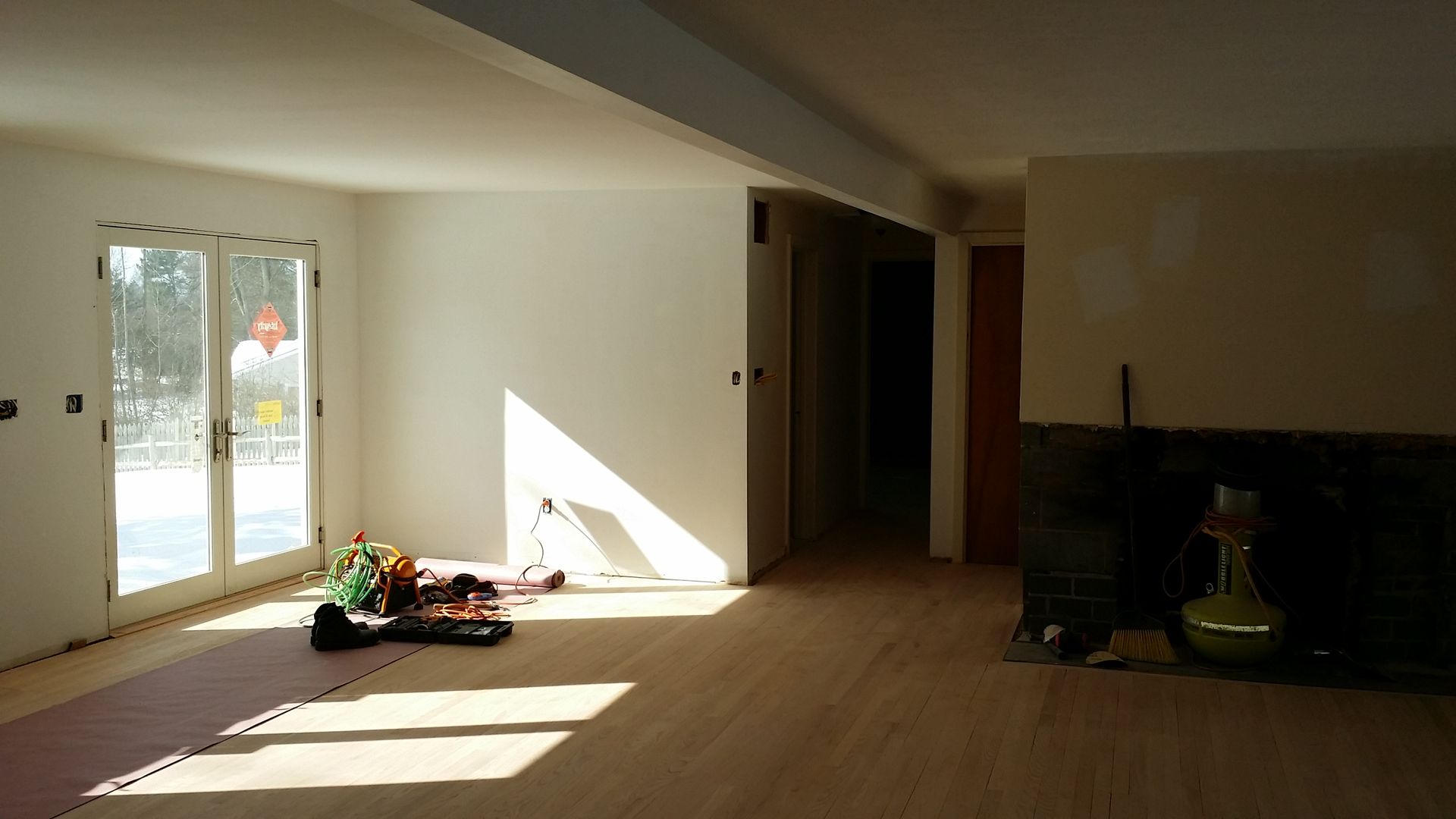 An empty living room with a fireplace and sliding glass doors