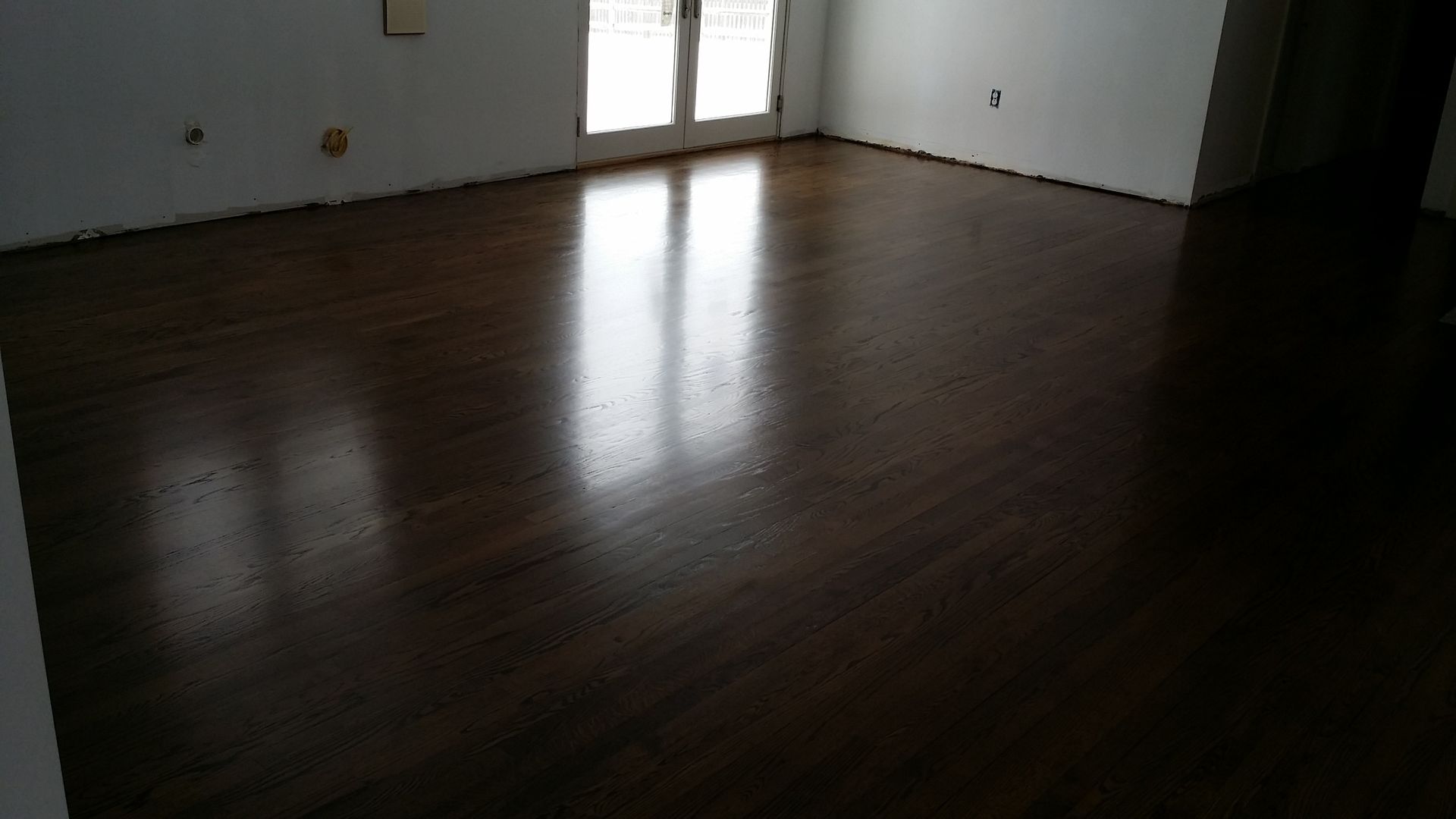 A living room with a wooden floor and white walls.