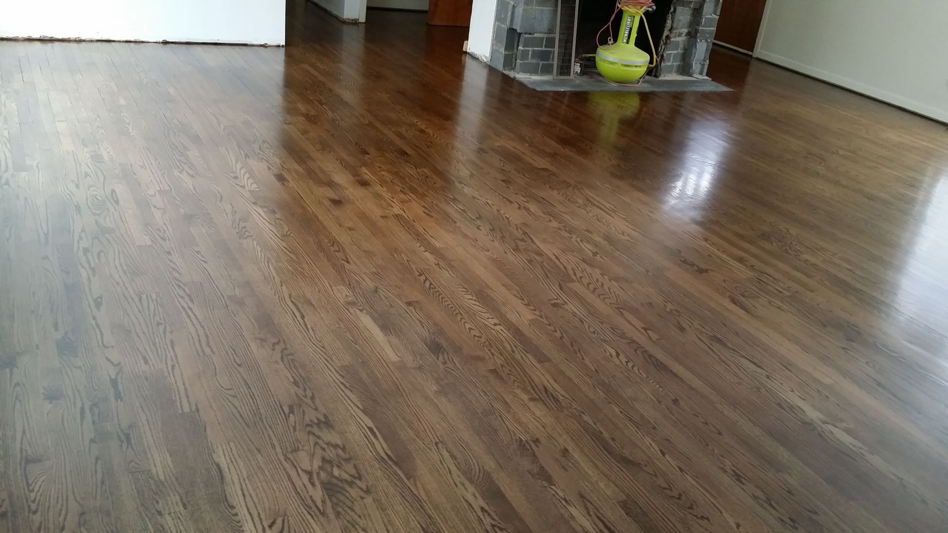 A living room with a wooden floor and a fireplace.