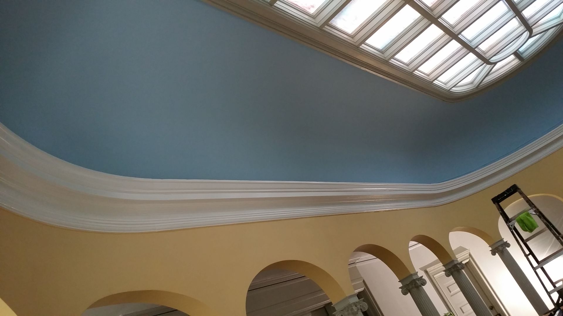 The ceiling of a building with arches and a skylight.