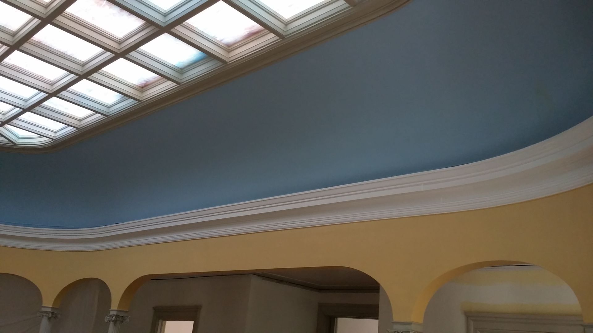 A room with a blue ceiling and a skylight.