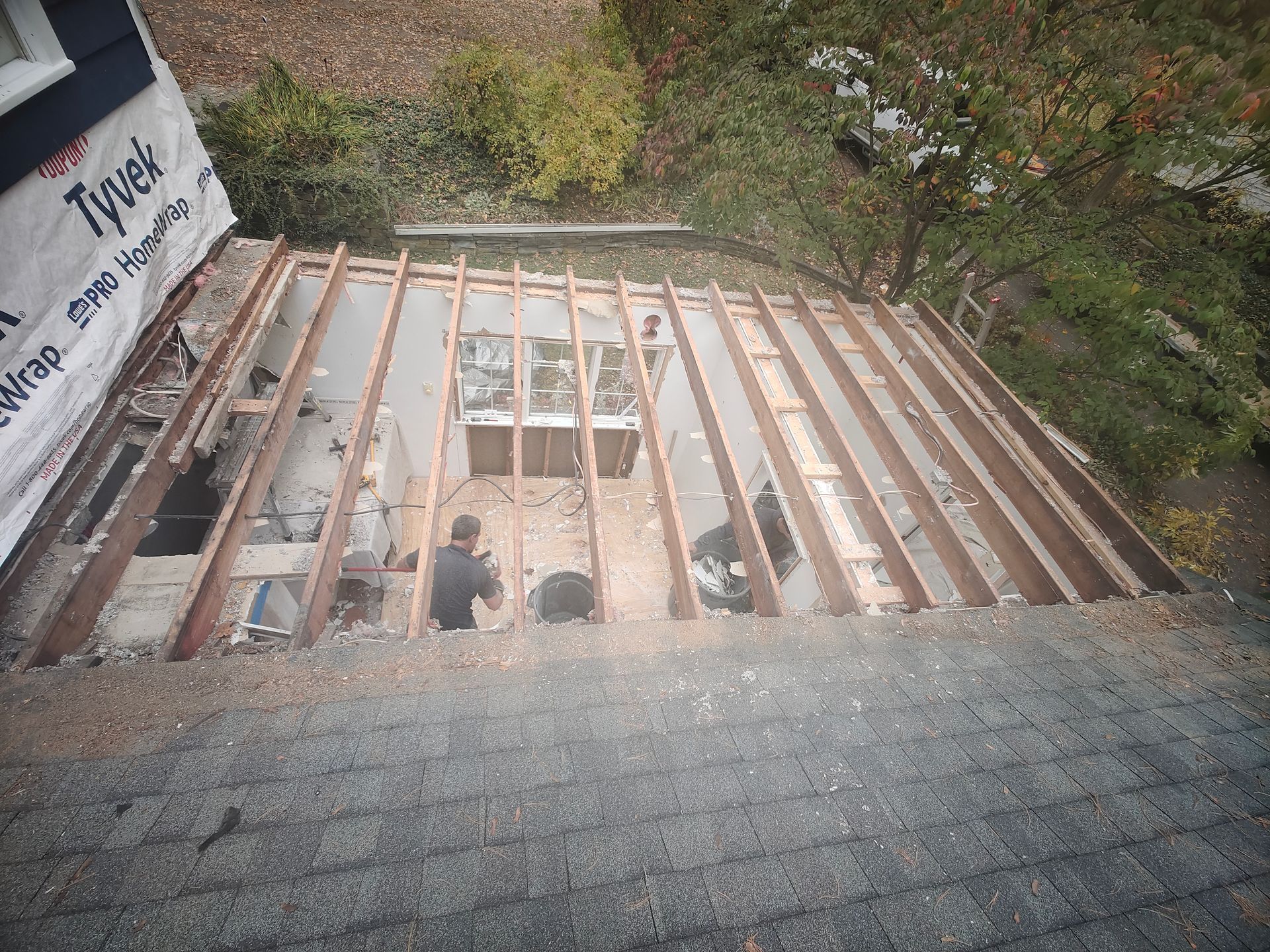 A group of people are working on the roof of a house.