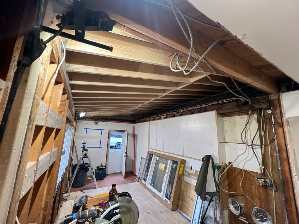A room with wooden beams and a lot of wires hanging from the ceiling.
