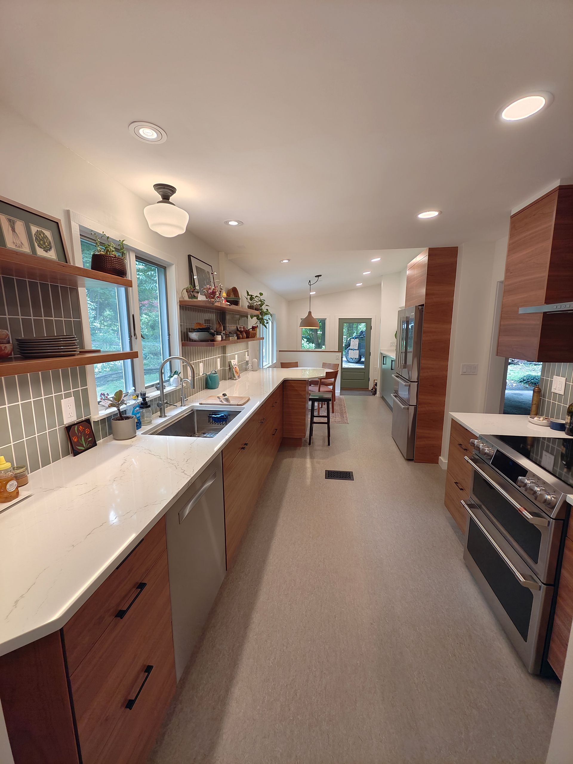 A long kitchen with wooden cabinets and stainless steel appliances.