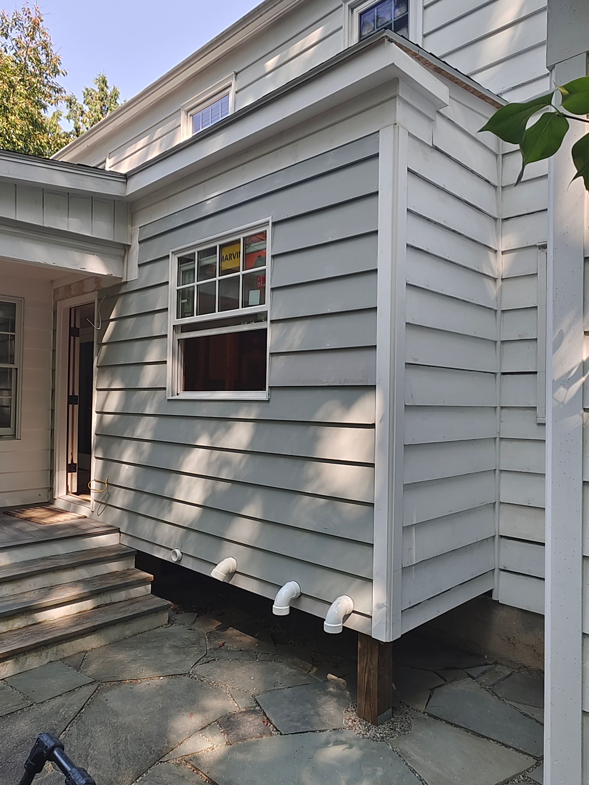 A white house with a window on the side of it.