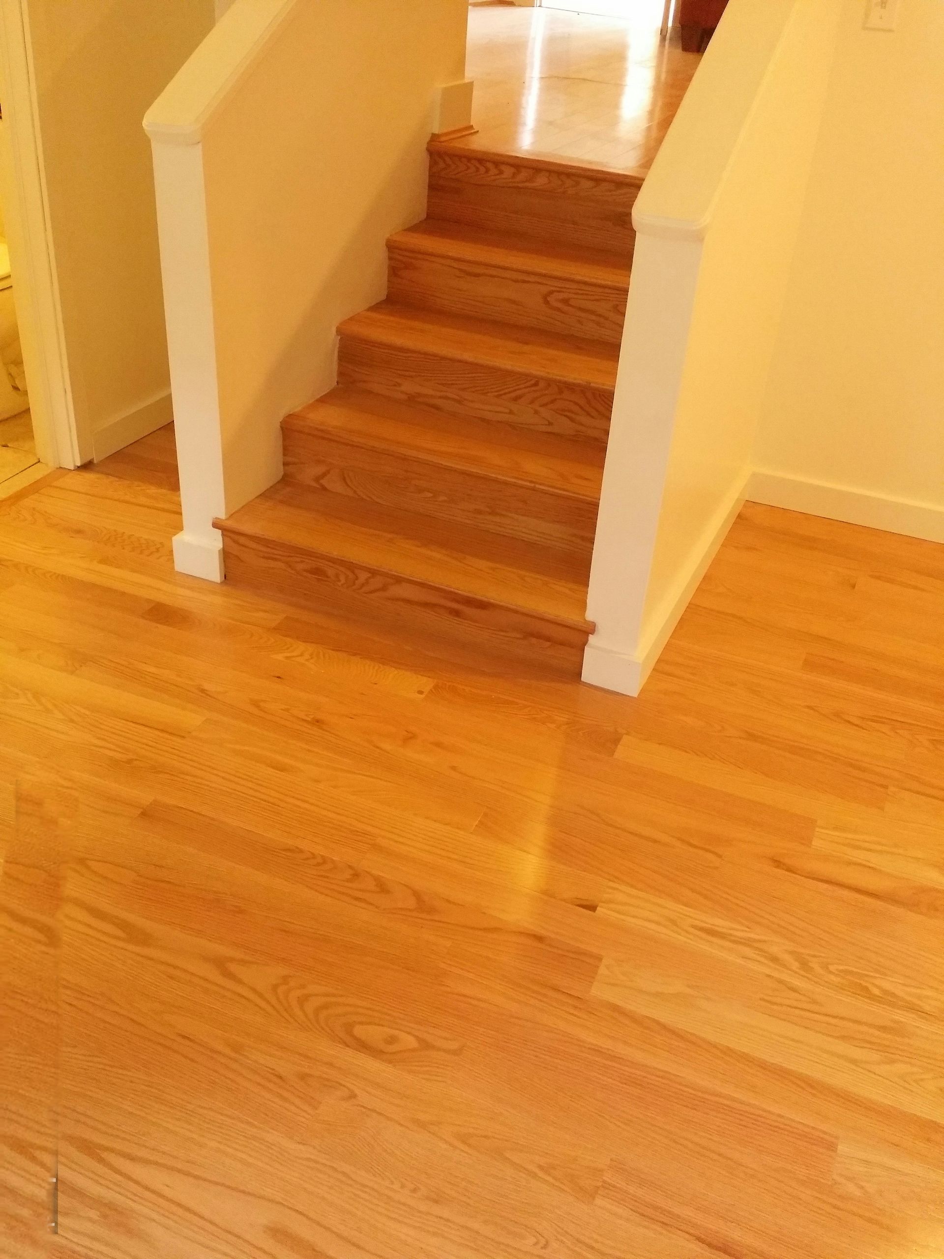 A set of wooden stairs in a room with hardwood floors