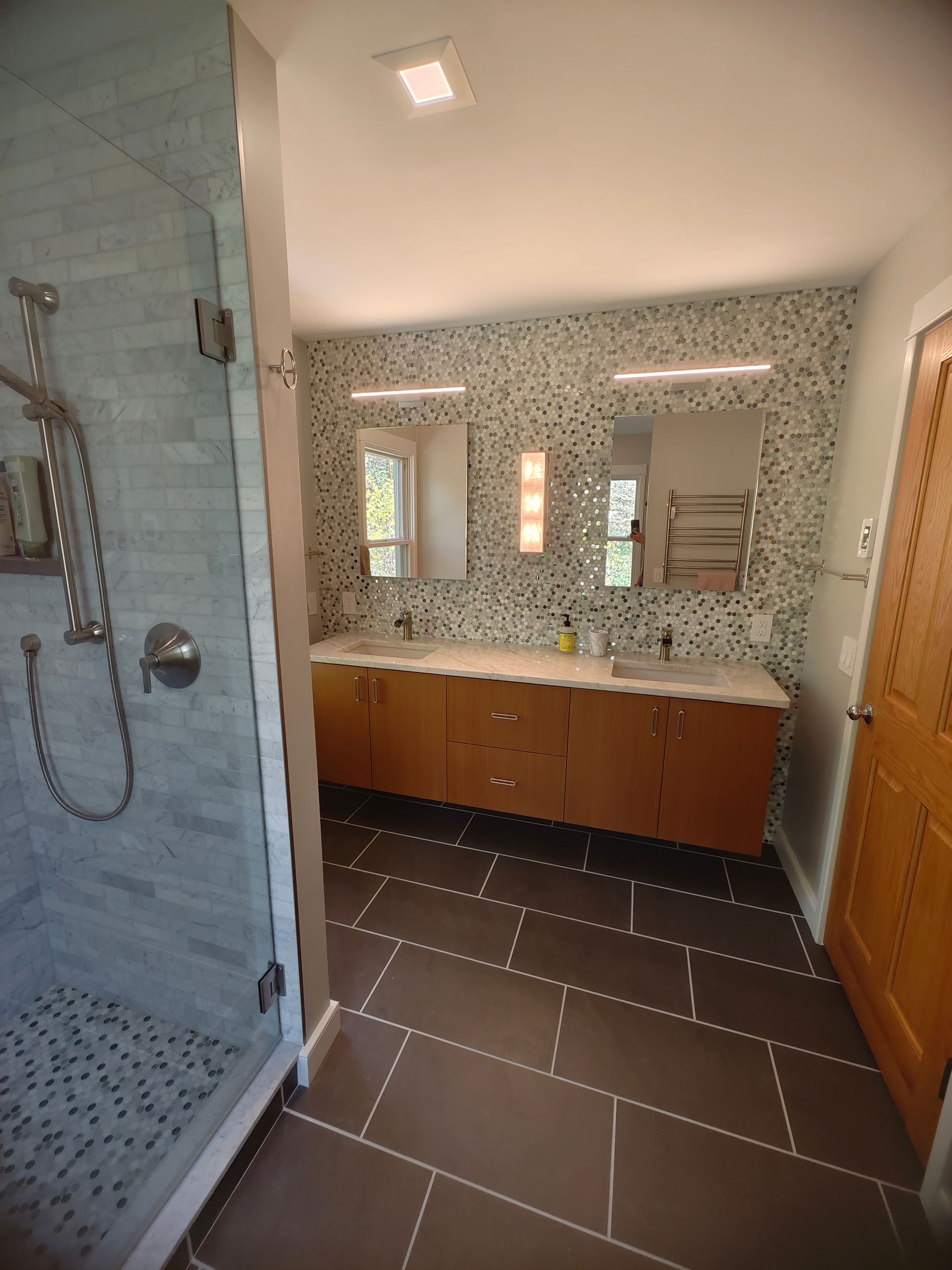 A bathroom with two sinks and a walk in shower
