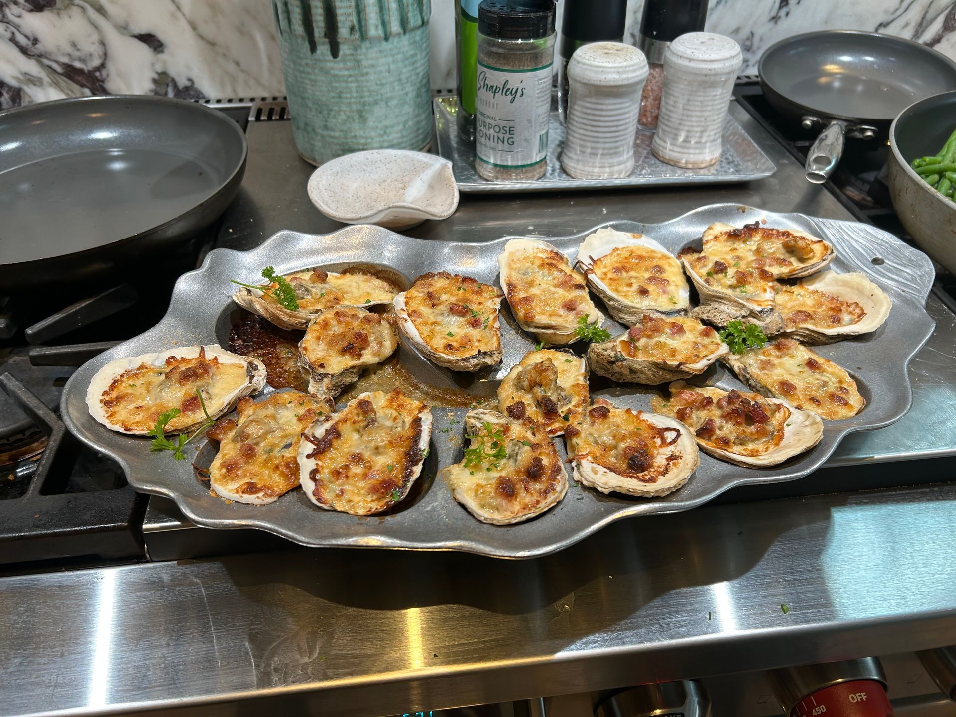 a tray of oysters sitting on top of a stove .— Mary Esther, FL — Bella Donna Catering