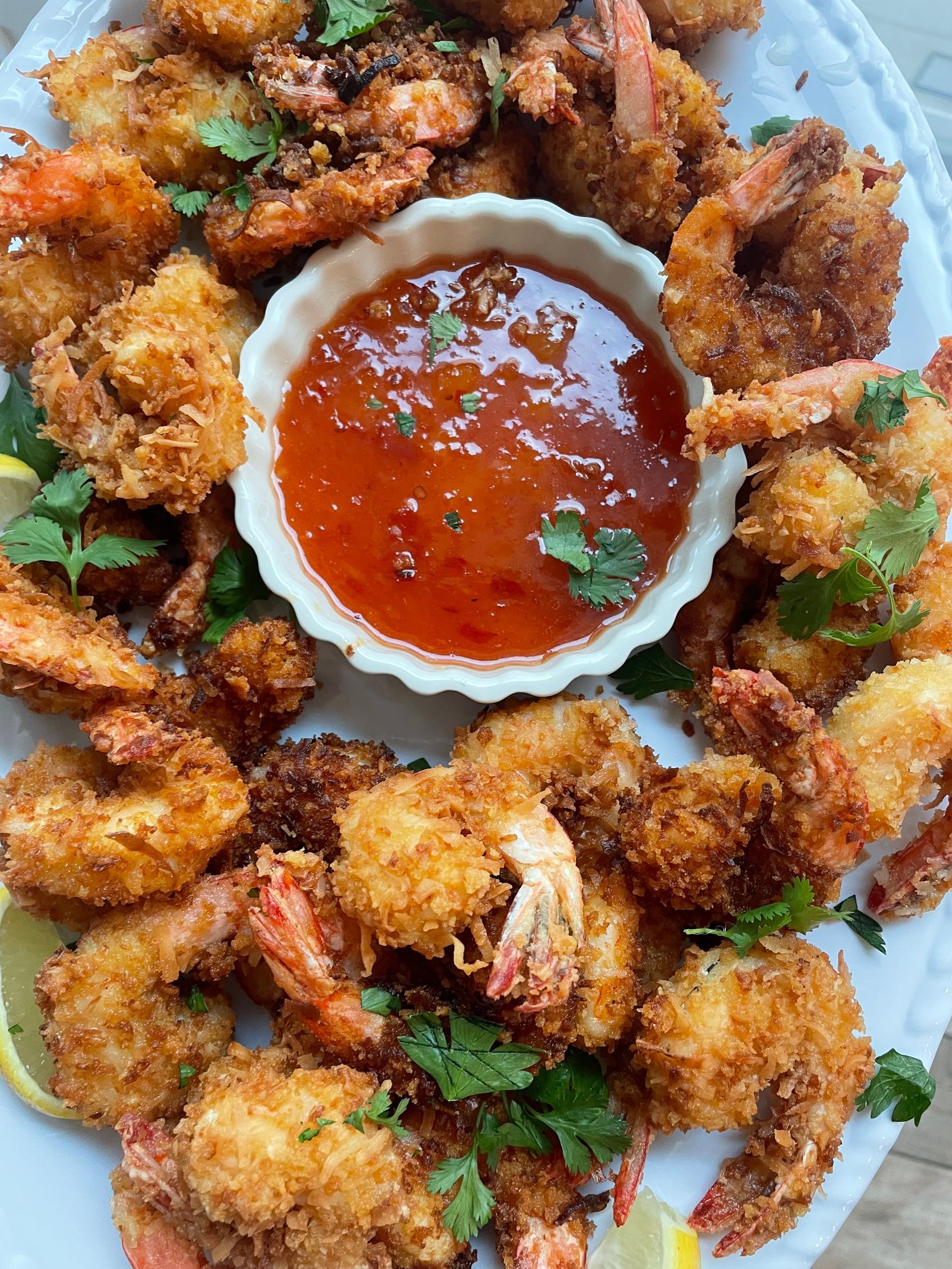 a white plate topped with fried shrimp and a bowl of sauce . — Mary Esther, FL — Bella Donna Catering