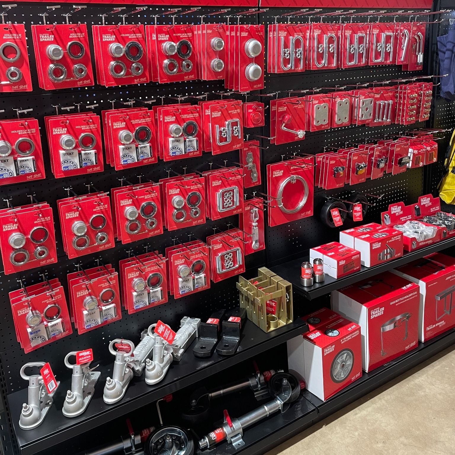 Red retail display wall packed with boxed items in a store aisle — Eastcoast Bearings & Hydraulics in Coffs Harbour, NSW