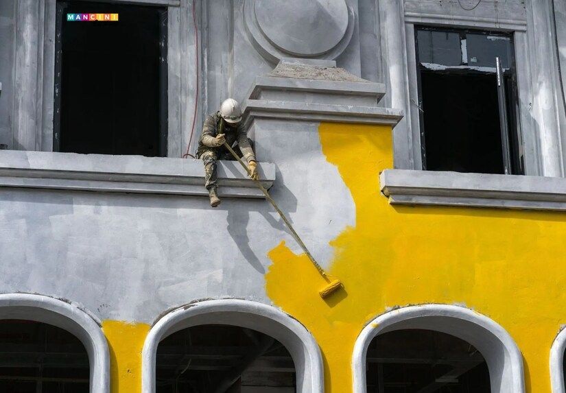 Guthrie painting contractor painting a building with yellow paint