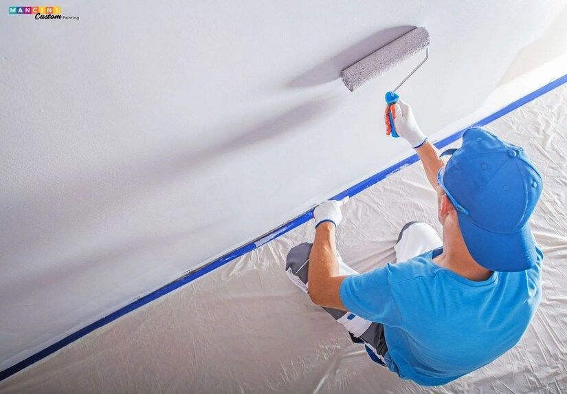 A painter in Edmond painting a ceiling with a roller