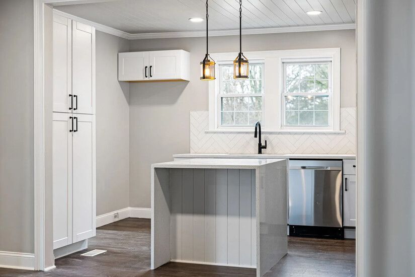 Renovated kitchen featuring freshly painted white cabinets