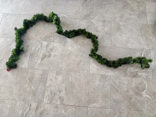 Green garland on a light gray tiled floor.