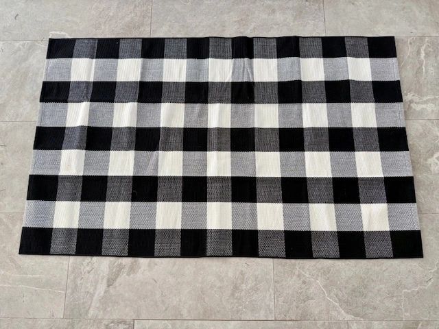 Black and white checkered rug on a light gray tiled floor.