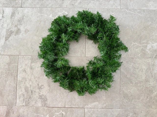Green wreath on a tiled wall.