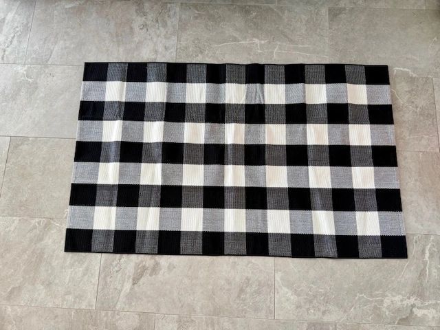 Black and white checkered rug on a light gray tiled floor.