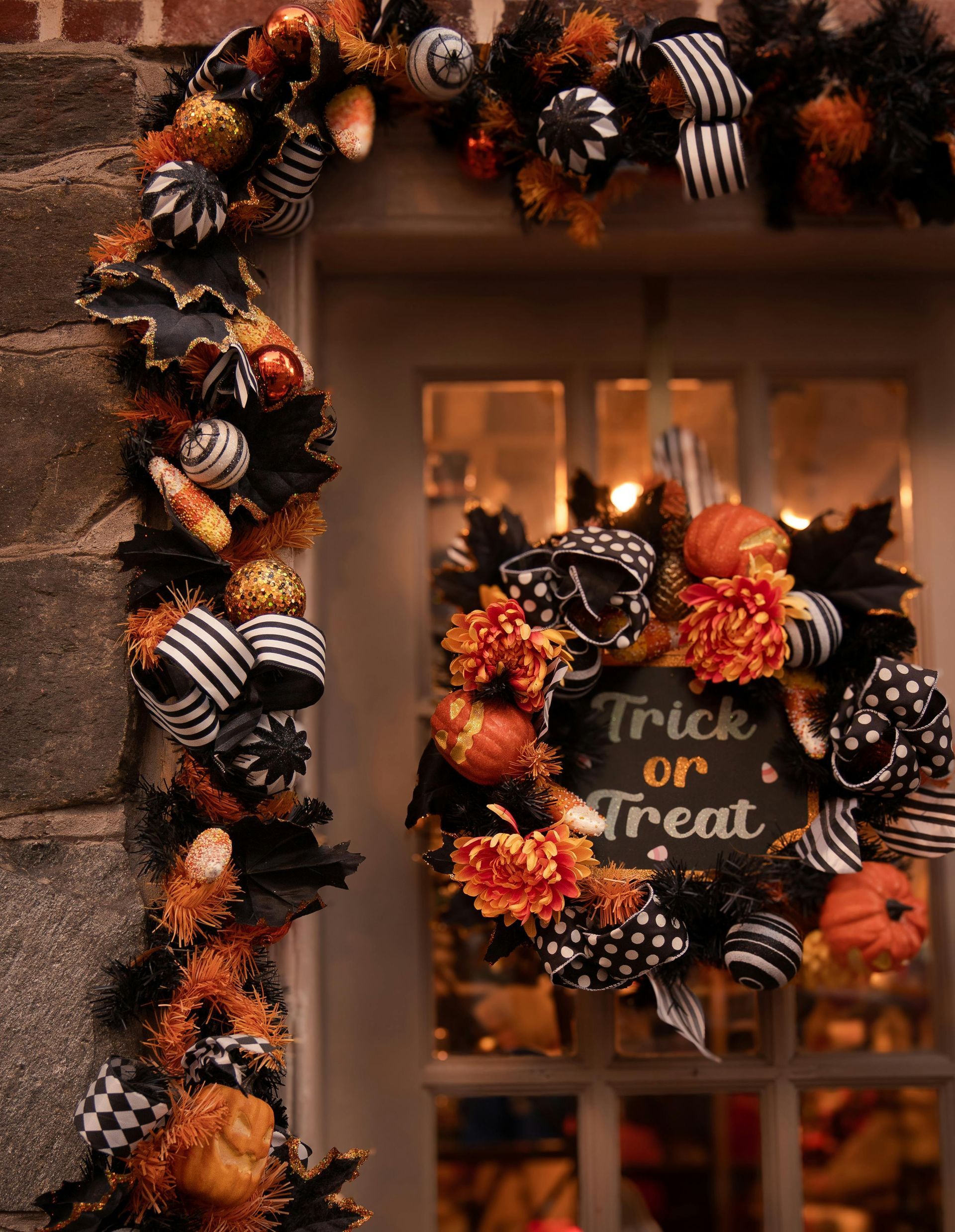 Halloween door decorated with black, orange, and white garland and a