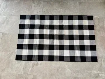 Black and white checkered rug on gray tiled floor.