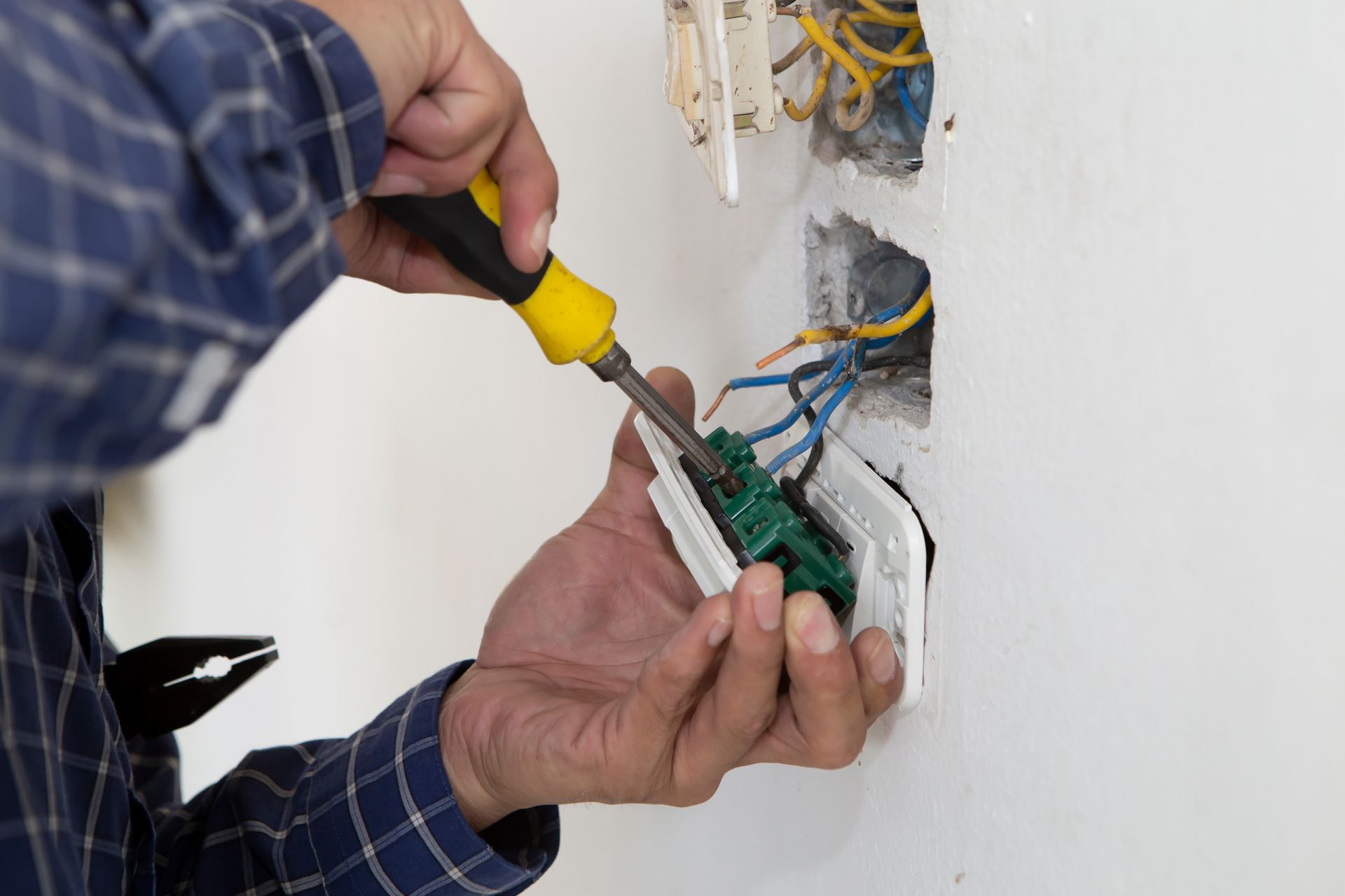 A man is fixing an electrical outlet 