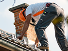 a man is working on the roof of a building .